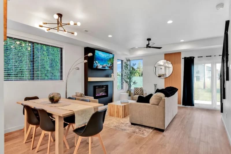 Open concept living and dining with fireplace wall